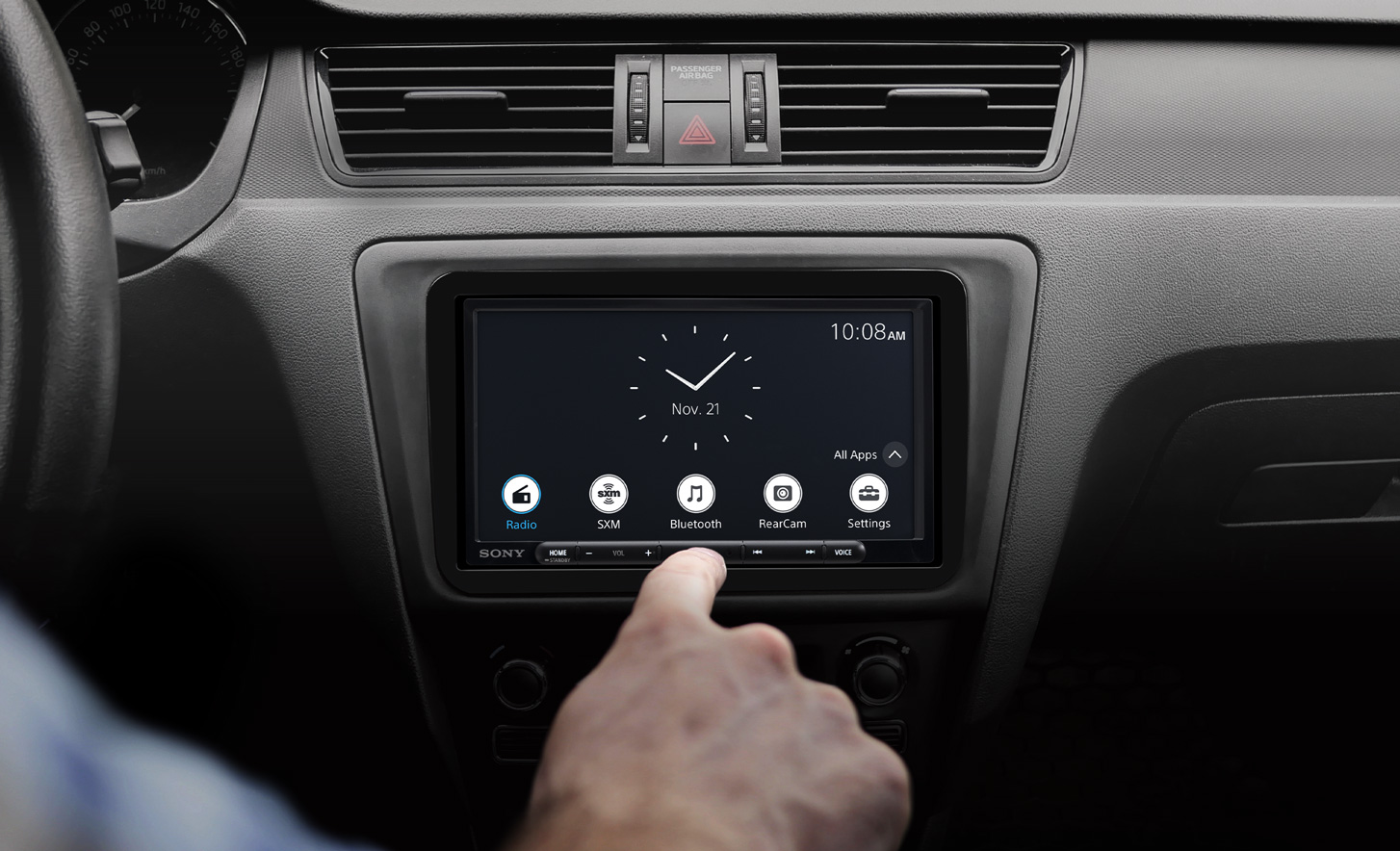 Front view of the XAV-AX3700 digital multimedia receiver installed on a car dashboard with a finger pressing the display.