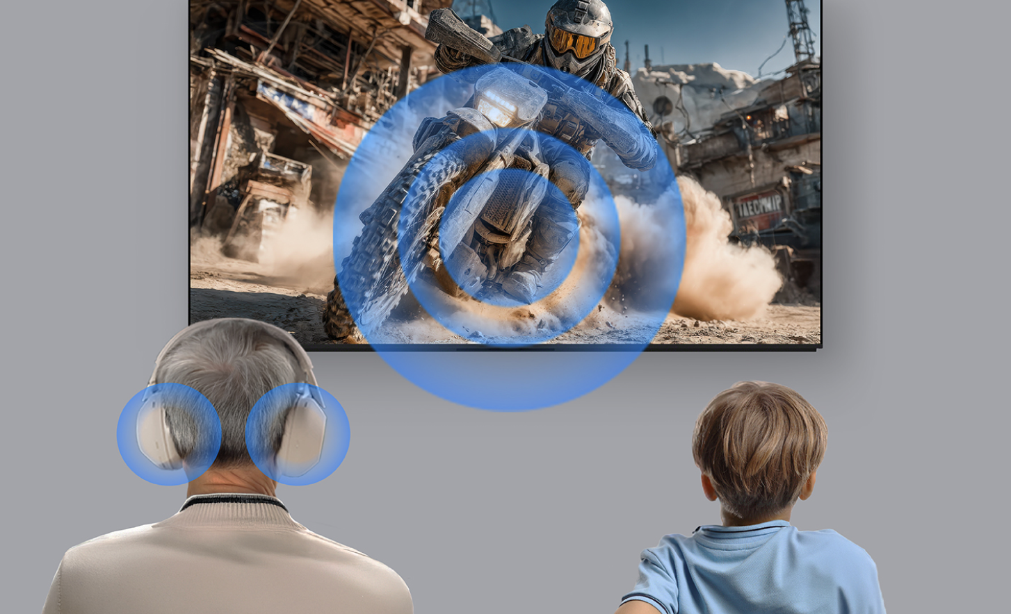 Une personne âgée portant des écouteurs et un enfant assis à côté d’elle regardent une scène d’action sur un écran de téléviseur. Des ondes sonores bleues se propagent de l’écran vers l’auditeur, illustrant la lecture audio partagée ou simultanée afin que les deux spectateurs ressentent le même son à partir du contenu.